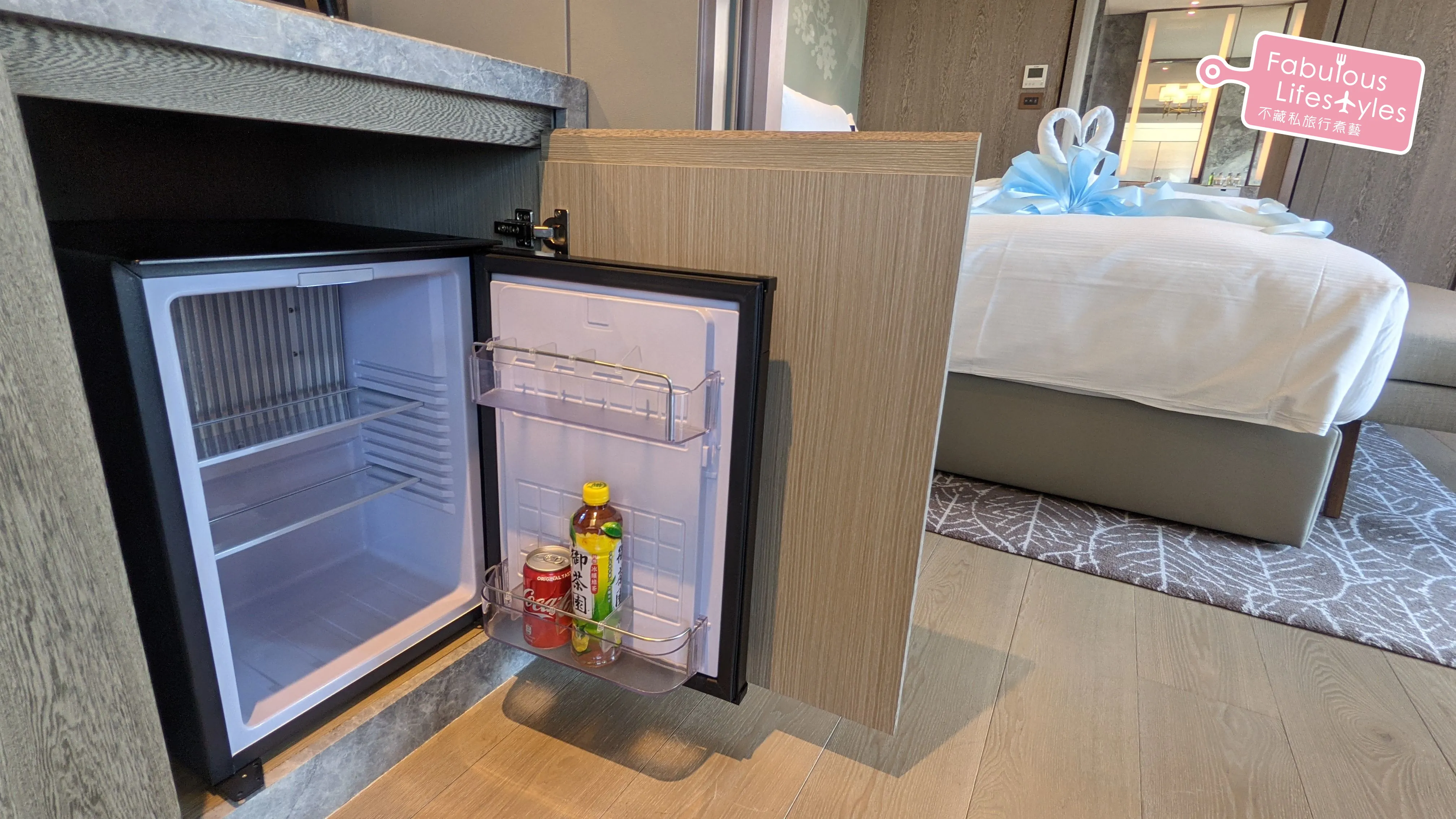 Mini fridge stocked with complimentary cola and green tea