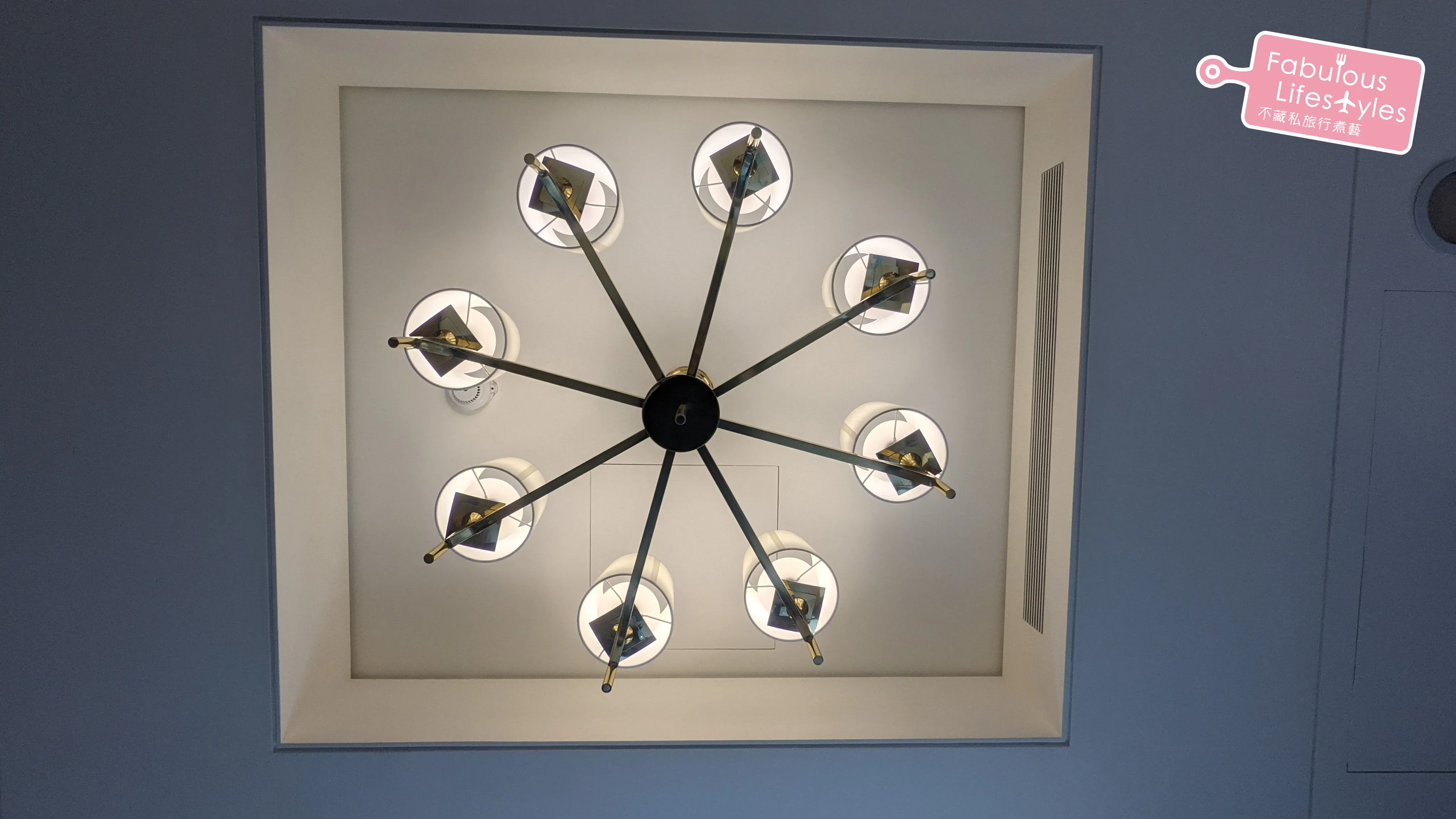 Eight-bulb torch-style chandelier above the bed